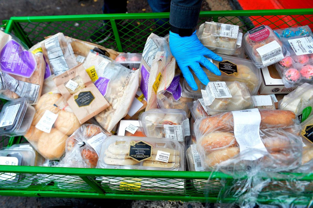 新型コロナ危機のさなかで食品などを数百人の人々に手渡すボランティア。2020年3月20日、マサチューセッツ州エバレットにて（PHOTOGRAPH BY JOSEPH PREZIOSO, AFP/GETTY）