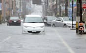 大雨特別警報が出された福井県小浜市の冠水した道路で立ち往生する車（16日午前8時30分ごろ）=共同