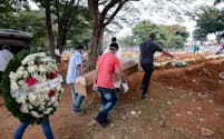 密閉された父親の棺を墓まで運ぶマノエル・ジョアキン・ダ・シウバ氏の息子たち。シウバ氏はCOVID-19の検査結果が出る前に79歳で死去した（PHOTOGRAPH BY GUI CHRIST）
