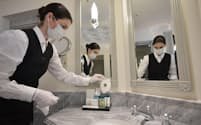 ドイツ、ベルリンの「ホテル・アドロン・ケンピンスキー」にて、従業員が客室のトイレにマスクを置く。2020年5月26日、新型コロナウイルス感染症のパンデミック（世界的な大流行）のさなか、制限が緩和され、観光客向けの営業が再開された翌日のこと（PHOTOGRAPH BY TOBIAS SCHWARZ, AFP VIA GETTY IMAGES）