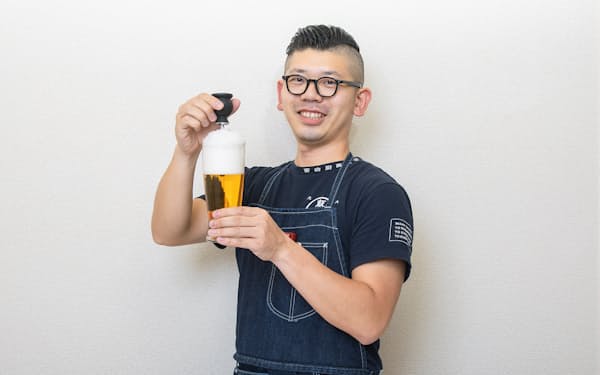 台所番長こと、合羽橋の老舗料理道具店、飯田屋の6代目、飯田結太氏。手にしているのは、缶から注いだビールの泡がクリーミーな泡に変わる「アエロメイト」