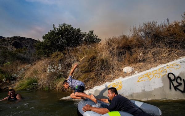 熱波が襲った米国カリフォルニア。エディー・ロペス氏と息子のエディー・ジュニア君がサンガブリエル川ではしゃぐ（PHOTOGRAPH BY ROBERT GAUTHIER, LOS ANGELES TIMES/GETTY IMAGES）