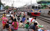 インドネシア・ジャカルタ市のドゥリ駅を発車する旧東急8500系車両。線路脇には住民が暮らしている。インドネシアでは珍しくない光景だという（2013年5月、斎藤幹雄さん撮影）