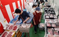 お買い得商品の肉をかごいっぱいに買う人も多い（東京都板橋区のクラショウ）=三浦秀行撮影