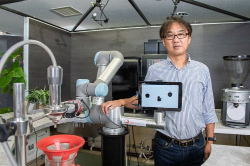 QBITロボティクス社長の中野浩也氏と、社内に展示したカフェロボット