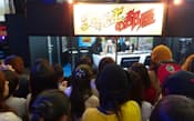東京ゲームショウでの人気実況者のコーナー。中をのぞき込んでいるのはすべて女性だ（13年9月）