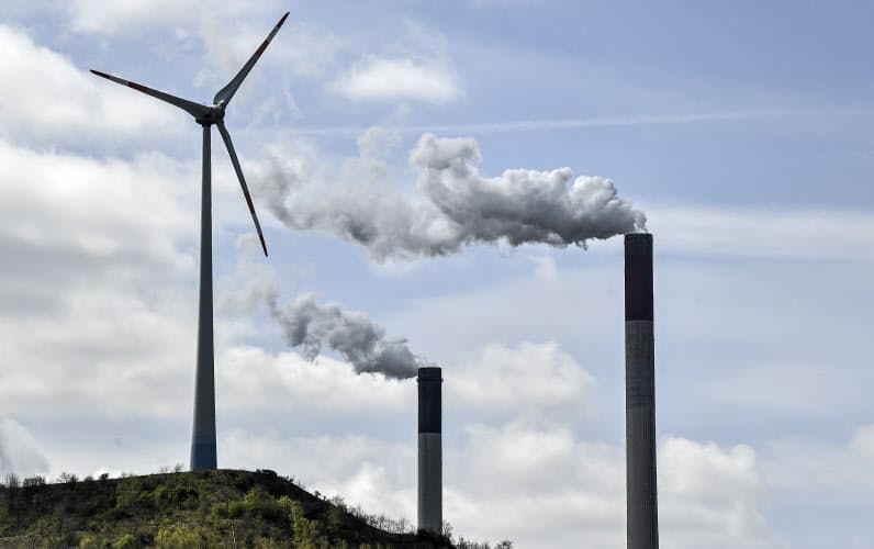 Chimneys of a coal-fired power plant smoke beside a wind turbine in Gelsenkirchen, Germany, Thursday, April 22, 2021. (AP Photo/Martin Meissner) Chimneys of a coal-fired power plant smoke beside a wind turbine in Gelsenkirchen, Germany, Thursday, April 22, 2021. (AP Photo/Martin Meissner)