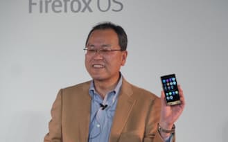 日本初のファイアーフォックスOS搭載スマートフォン「Fx0」を手に持つKDDIの田中孝司社長