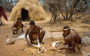 人工照明その他の電力を使わず、伝統的な野営生活を営むタンザニアのハッザ族。男たちがディクディク（小型のアンテロープ）をさばいている。健康状態や寿命はさておき、彼らが先進国の人々に比べて長く眠っているわけではないことが、最近の研究で分かった。（Photograph by Martin Schoeller, National Geographic）