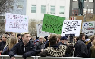 アイスランドの首都レイキャビクでグンロイグソン首相に抗議する人たち=ロイター