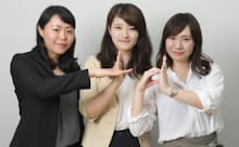 NTTドコモ 有本香織氏(左、地域協創・ICT推進室)、市橋咲氏(中央、新潟支店法人営業部)、松本英里子氏(右、九州支社法人営業部)。パートナー企業とドコモの協創を意味する「+d(プラスディー)」のポーズをとったところ。