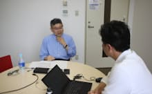 本社の課長からヒアリングを行う筆者(左)