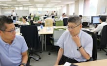 社内で打ち合わせをする筆者(右)