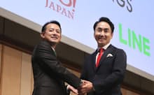 経営統合の記者会見で握手するZホールディングスの川辺健太郎社長(左)とLINEの出沢剛社長(右)、2019年11月18日、東京都港区で撮影