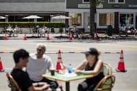 2020年6月13日、米ニューヨーク州イーストハンプトン。ニュータウン通りの両側にレストランのテーブルが並び、客が食事を楽しむ(PHOTOGRAPH BY KARSTEN MORAN, THE NEW YORK TIMES VIA REDUX) 2020年6月13日、米ニューヨーク州イーストハンプトン。ニュータウン通りの両側にレストランのテーブルが並び、客が食事を楽しむ(PHOTOGRAPH BY KARSTEN MORAN, THE NEW YORK TIMES VIA REDUX)