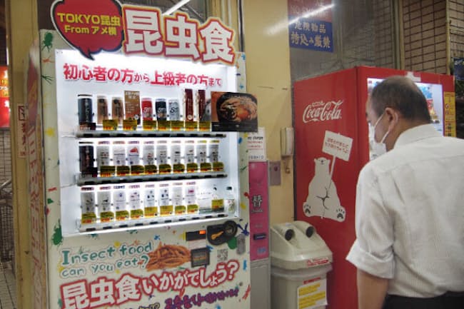 食用の昆虫を販売する自販機が都内5カ所に設置されている。写真はアメ横センタービルで稼働中のもの。昆虫の姿そのままの商品やコオロギ粉末を練り込んだせんべい、うどんなど食品が多数。飲料はタガメサイダーがあった。価格は450~2700円 食用の昆虫を販売する自販機が都内5カ所に設置されている。写真はアメ横センタービルで稼働中のもの。昆虫の姿そのままの商品やコオロギ粉末を練り込んだせんべい、うどんなど食品が多数。飲料はタガメサイダーがあった。価格は450~2700円