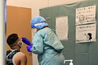 検体を採取する医療従事者。検査能力拡充には医療機関の協力が欠かせない(成田空港) 検体を採取する医療従事者。検査能力拡充には医療機関の協力が欠かせない(成田空港)