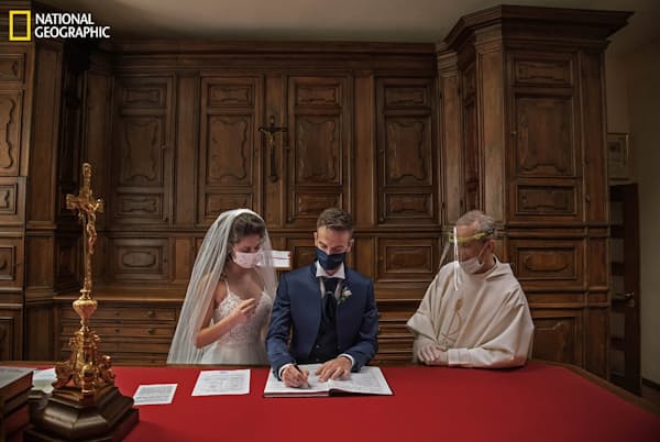 2020年5月23日:外出規制の解除後、ミラノに近い聖ビト教会でマスクを着けて挙式するマルタ・コルツァーニとアレッシオ・カバラロ。披露宴では家族だけが祝福のハグをした(PHOTOGRAPH BY DAVIDE BERTUCCIO) 2020年5月23日:外出規制の解除後、ミラノに近い聖ビト教会でマスクを着けて挙式するマルタ・コルツァーニとアレッシオ・カバラロ。披露宴では家族だけが祝福のハグをした(PHOTOGRAPH BY DAVIDE BERTUCCIO)