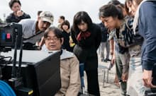 映画ロケの現場でモニターをチェックする本木克英監督(左から3人目)と主役の井上真央さん(右から2人目)(c)2021「大コメ騒動」製作委員会